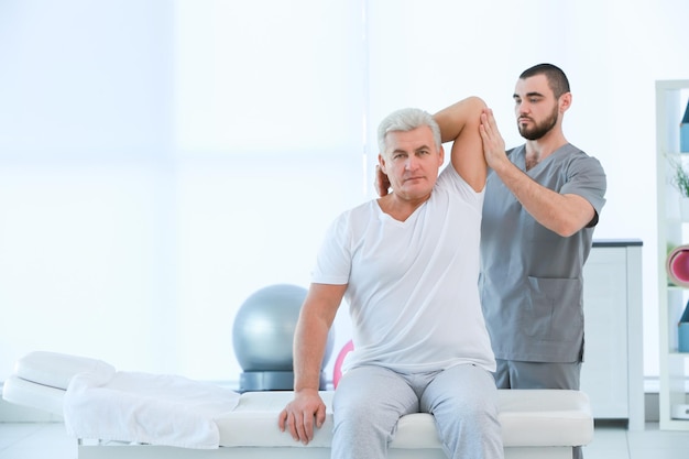 Physiotherapeut, der mit Patienten in der Klinik arbeitet