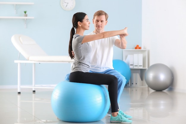 Physiotherapeut, der mit Patientin im Rehabilitationszentrum arbeitet