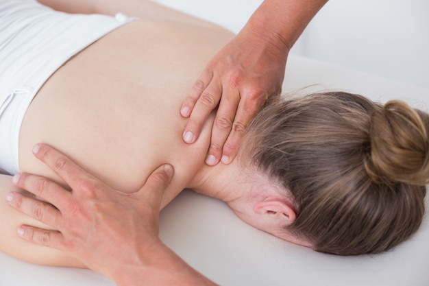 Foto physiotherapeut, der nackenmassage zu seinem patienten tut