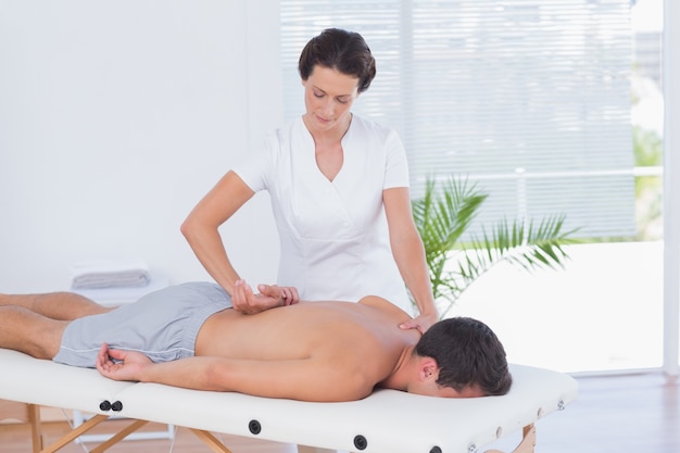 Physiotherapeut, der Rückenmassage tut