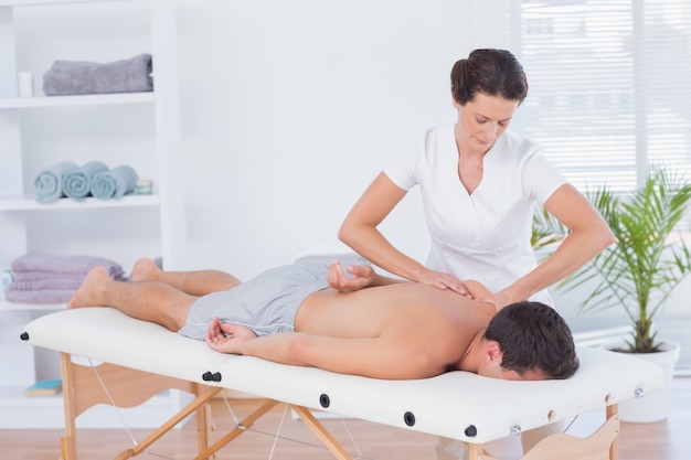 Physiotherapeut, der Rückenmassage tut