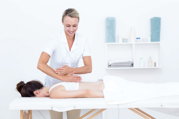 Physiotherapeut, der Rückenmassage tut