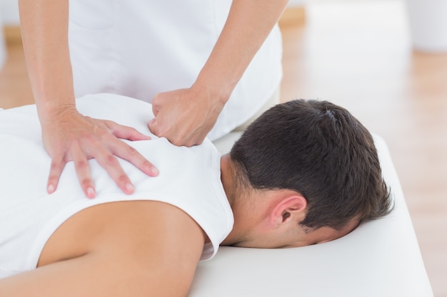 Physiotherapeut, der Rückenmassage tut