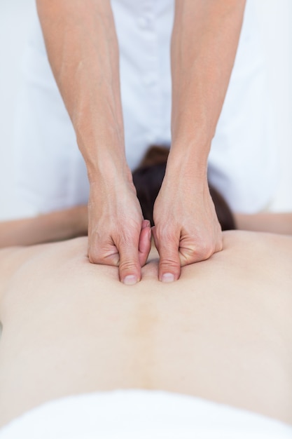 Physiotherapeut, der Rückenmassage tut