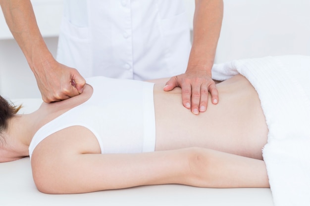 Physiotherapeut, der Rückenmassage tut