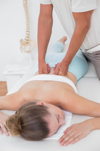 Physiotherapeut, der Rückenmassage tut