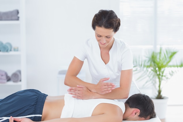 Physiotherapeut, der Rückenmassage tut