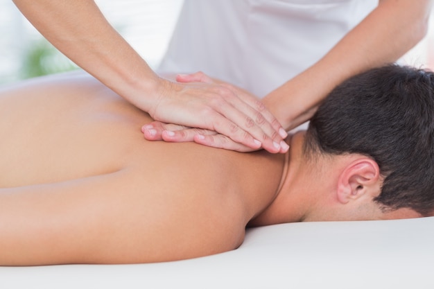 Physiotherapeut, der Rückenmassage zu ihrem Patienten tut