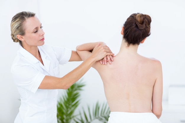 Physiotherapeut, der Schultermassage tut