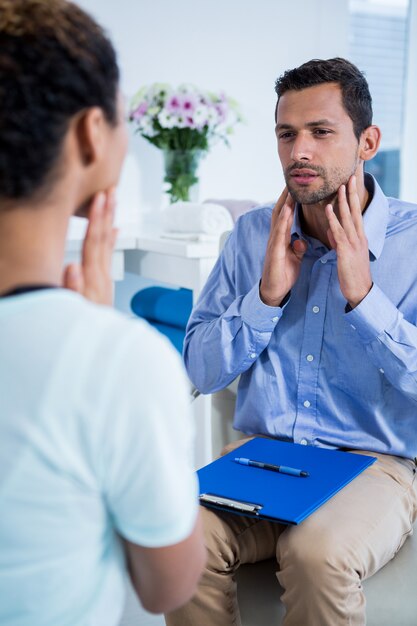 Physiotherapeut im Gespräch mit Patienten mit Nackenschmerzen