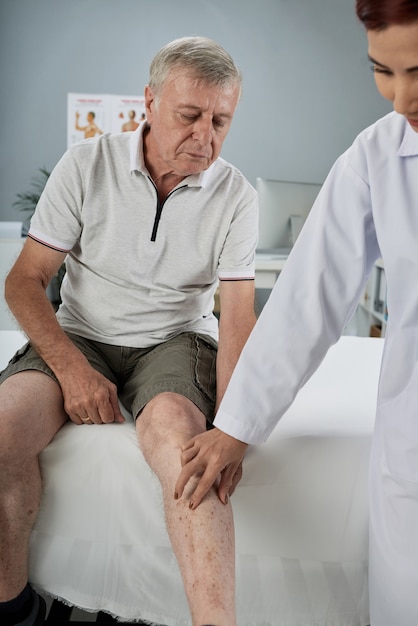 Physiotherapeut überprüft verletztes Bein