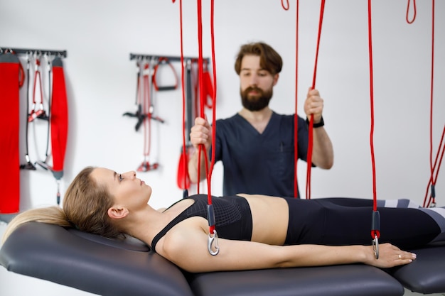 Physiotherapeut unterstützt Patientin bei rehabilitativer Physiotherapie