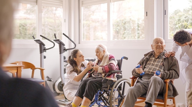 Physiotherapeuten sprechen mit älteren Menschen, während sie in der Geriatrie trainieren