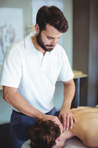 Foto physiotherapeutin, die einer frau eine nackenmassage gibt