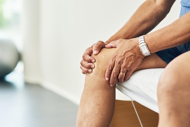 Foto physiotherapie-knieschmerzen und verletzungen an den beinen eines mannes im raum für medizinische beratung und arthritis-rehabilitation von muskeln und gelenken mit nahaufnahme des patienten in der klinik für physiotherapie und heilung
