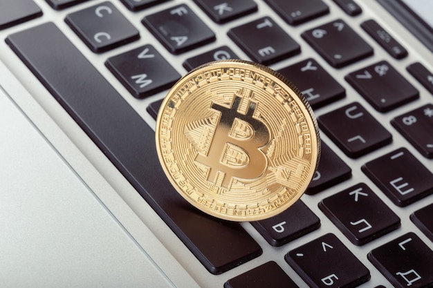 Physisches Münzensymbol goldenen bitcoin auf Tastatur