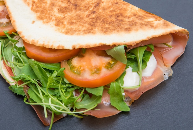 Piadina romagnola típica com presunto, queijo e rúcula