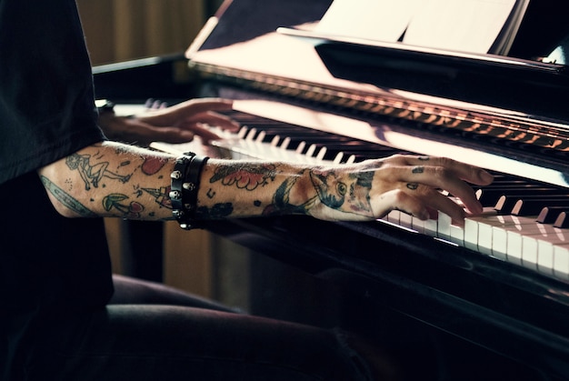 Pianista practicando en un piano de cola con música clásica.