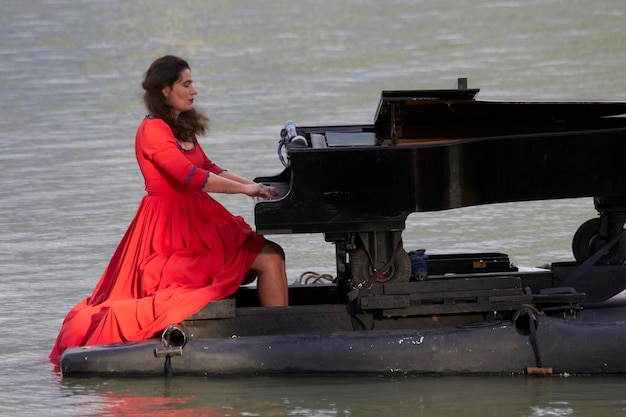 Pianista tocando el piano en el lago