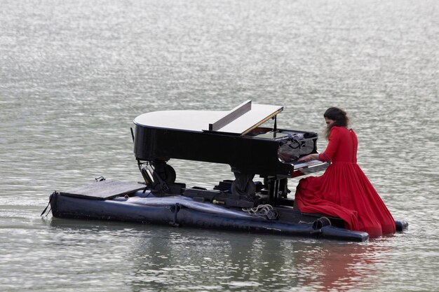 Pianista tocando el piano en el lago