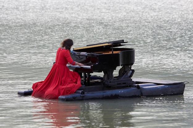 Foto pianista tocando el piano en el lago