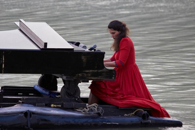 Foto pianista tocando el piano en el lago