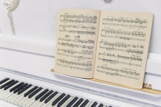 piano blanco con un libro con notas en él