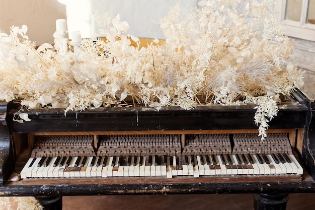 Piano de cola antiguo con flores blancas