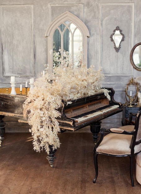 Piano de cola antiguo con flores blancas