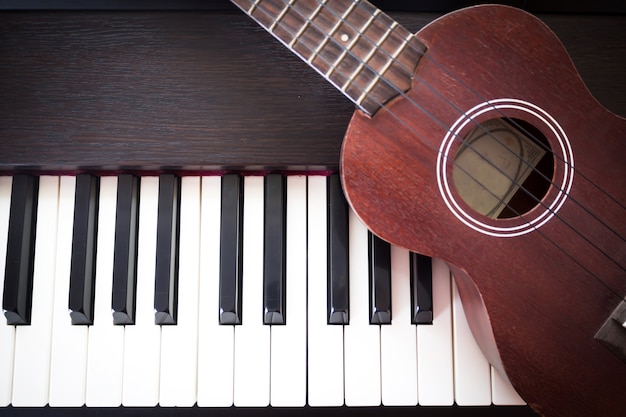 Foto piano con ukelele fondo de arte y música. dos tipos de instrumentos de música.