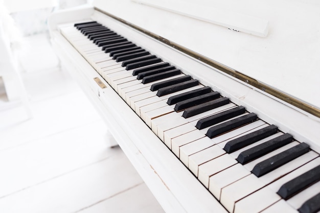 Piano vintage blanco en una habitación blanca