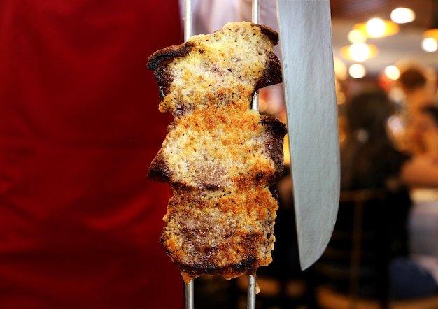 Picanha bife tradicional brasileiro em churrasco Fatias de picanha grelhada com alho em fundo vermelho com espaço de cópia