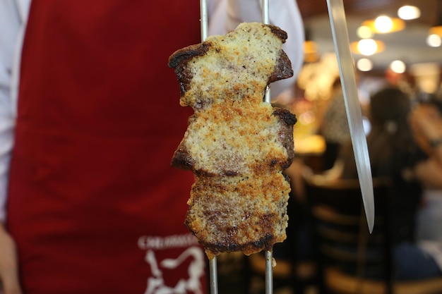 Picanha bife tradicional brasileiro em churrasco Fatias de picanha grelhada com alho em fundo vermelho com espaço de cópia