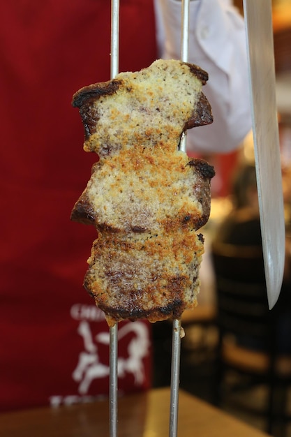 Picanha Brasilianisches traditionelles Steak im Grill Scheiben gegrillter Picanha mit Knoblauch auf rotem Hintergrund mit Kopierraum