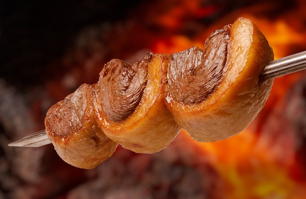 Foto picanha churrasco assado no espeto na brasa churrasco é muito consumido em todo brasil