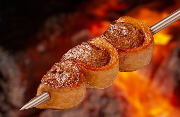 Foto picanha churrasco assado no espeto na brasa churrasco é muito consumido em todo brasil