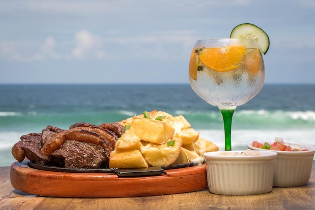 Picanha, un corte tradicional de carne brasileña, servido con mandioca frita en un plato caliente.