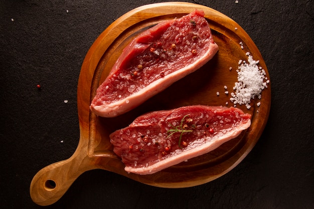 Picanha crua, tradicional corte de carne brasileira em fundo preto. Vista do topo.