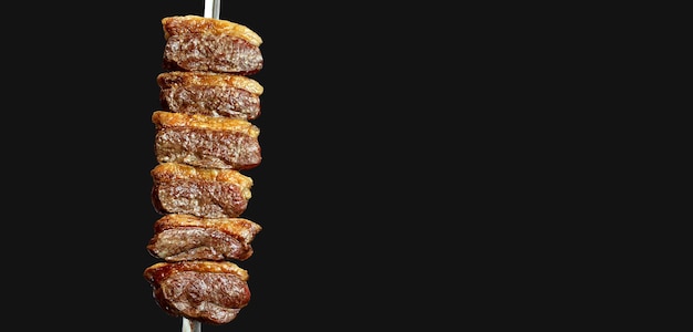 Foto picanha tradicional bife brasileiro no churrasco fatias de picanha grelhada no espeto fundo do restaurante