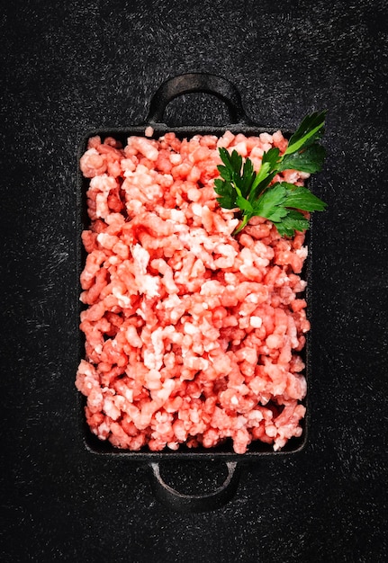 Picar carne picada moída com ingredientes para cozinhar em fundo preto Espaço de cópia de vista superior