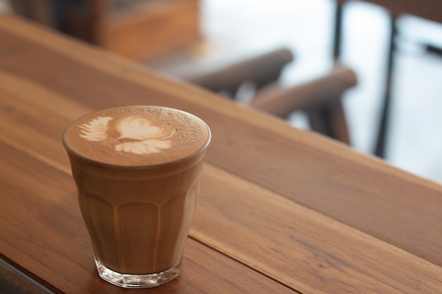 Piccolo Latte arte en vaso pequeño en escritorio de madera