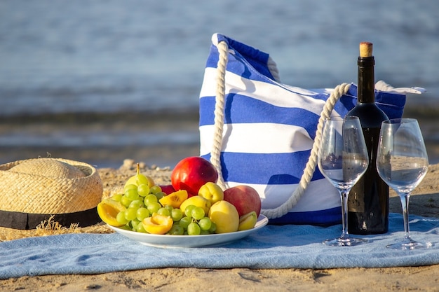 Picknickdecke, Wein, Obst, schöner Meeresstrand. Selektiver Fokus