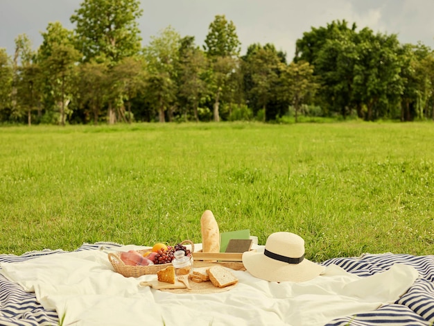 Picknickkonzept Auf dem weißen Tuch stehen viele Dinge wie Brotfrüchte eine Flasche Wasser