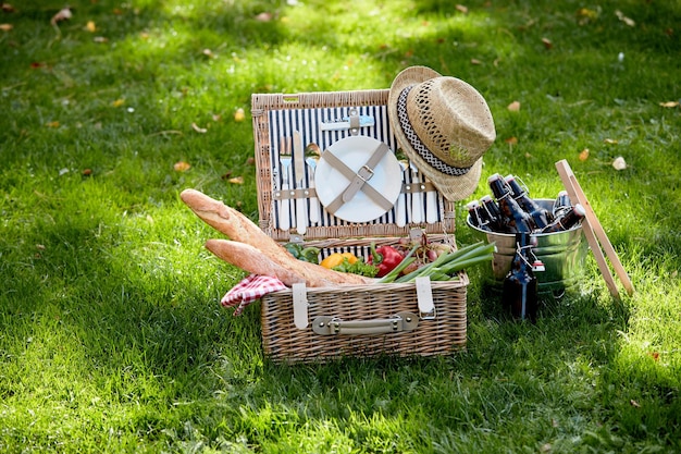 Picknickkorb mit Baguettes und Gemüse auf Rasen