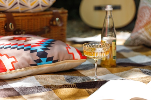 Picnic al aire libre con un vaso de limonada sobre una alfombra beige a cuadros y una almohada para acampar vacaciones Descansar solo