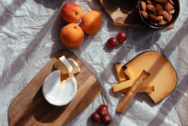 Picnic al atardecer con varios tipos de queso y fruta.