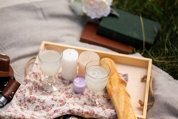 Picnic de boda en la hierba Vasos baguette manta libros velas