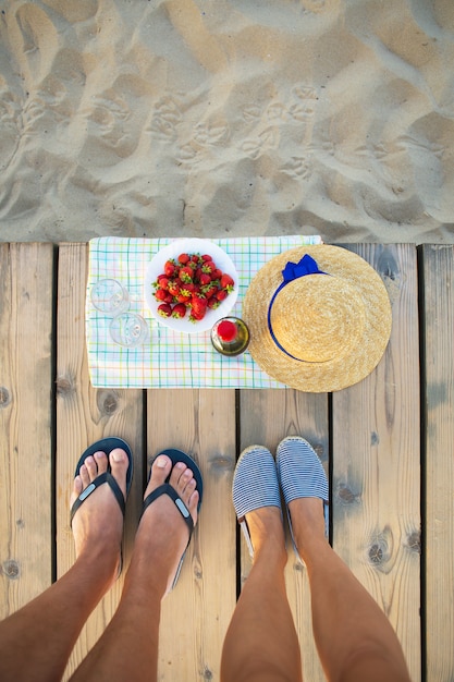 Picnic cerca del sombrero de mar, vino, copas, fresa.