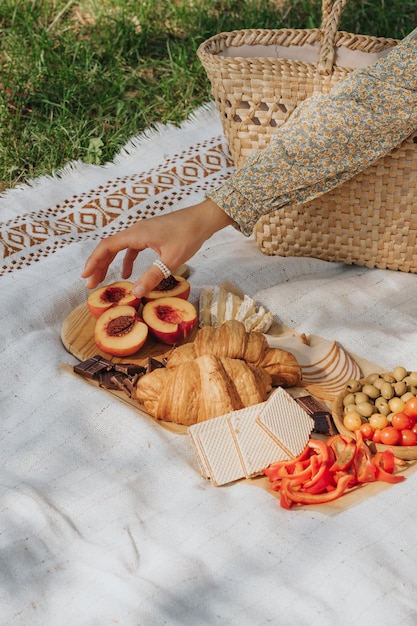 Picnic en el césped con aperitivos ligeros en el contexto de una cesta de paja Desayuno francés