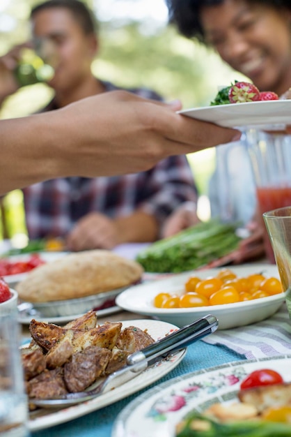 Un picnic familiar en un bosque sombreado Adultos y niños sentados en una mesa